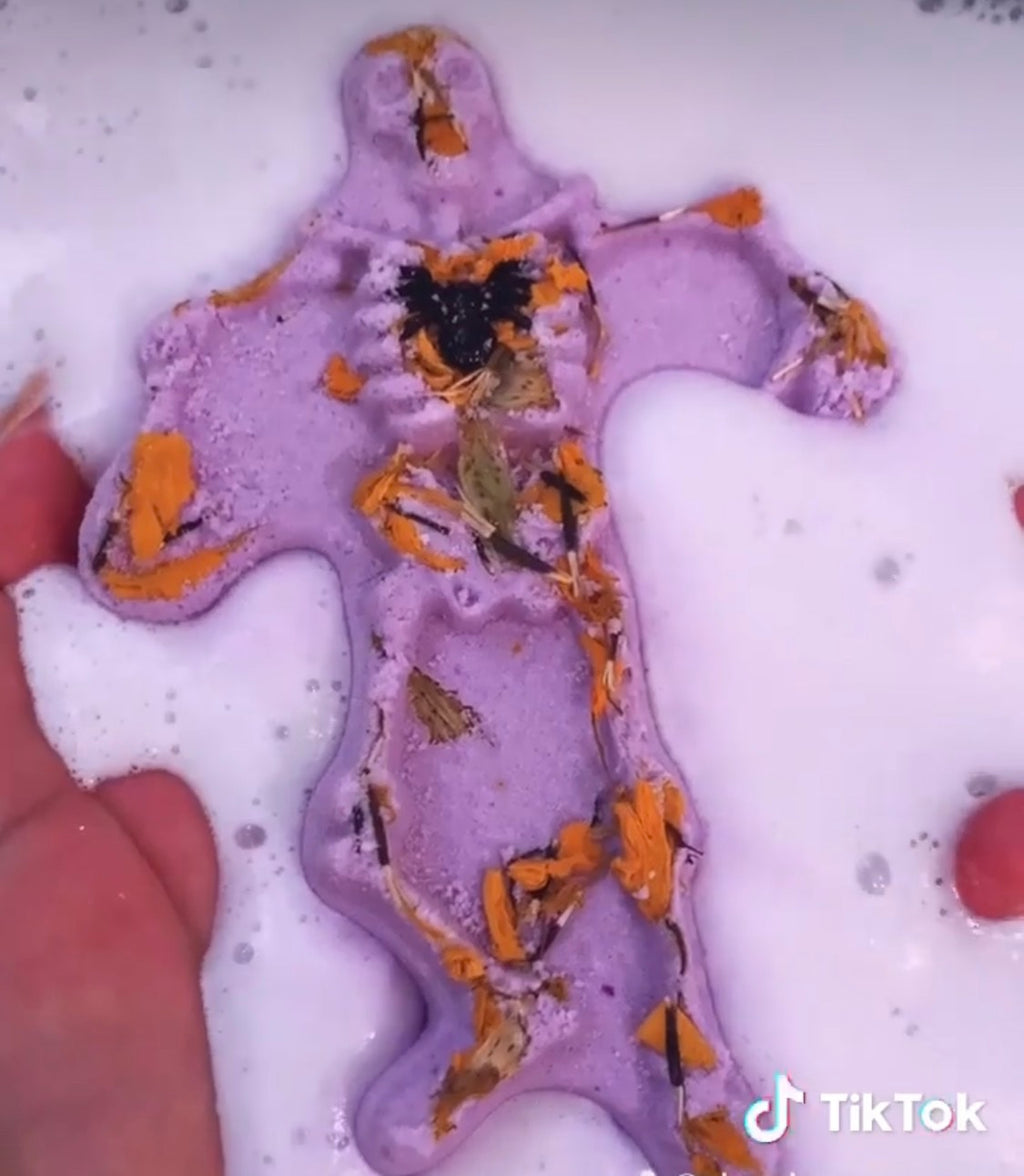 Spooky Scary Skeletons bath bomb dissolving in bath foam with marigold petals